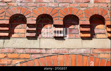 Viele kleine rote Bögen aus Backstein an der Fassade Stockfoto
