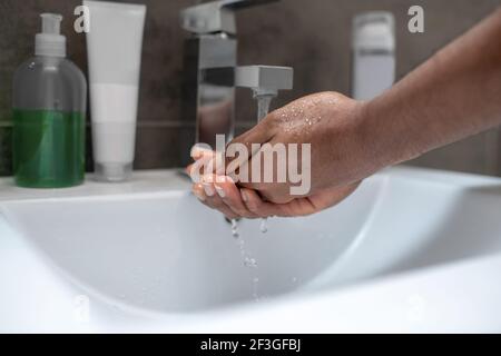 Nahaufnahme von mans Händen und einem Wasserbecken Stockfoto