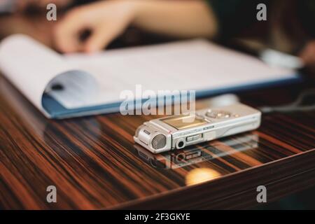 Bild mit geringer Schärfentiefe (selektiver Fokus) mit einem Audiorecorder einer Journalistin während eines Interviews. Stockfoto