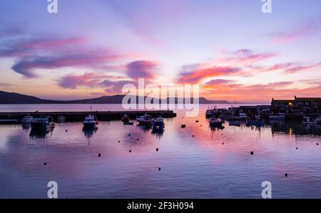 Lyme Regis, Dorset, Großbritannien. März 2021, 17th. UK Wetter: Spektakuläre Sonnenaufgangsfarbe über dem Cobb bei Lyme Regis zu Beginn eines schönen Frühlingstages. Kredit: Celia McMahon/Alamy Live Nachrichten Stockfoto