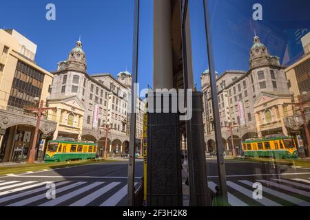 Kagoshima, Japan, 20. März 2020 - Straßenbahn mit historischem Yamakata-ya Gebäude im Einkaufsviertel in Tenmonkan, Kagoshima, Japan. Stockfoto