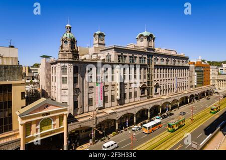 Kagoshima, Japan, 20. März 2020 - Straßenbahn mit historischem Yamakata-ya Gebäude im Einkaufsviertel in Tenmonkan, Kagoshima, Japan. Stockfoto