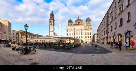 Augsburg, Deutschland, 08/23/2019: Perlachturm mit Rathaus in der Innenstadt von Augsburg. Im Vordergrund stehen Tische, Stühle und Sonnenschirme Stockfoto