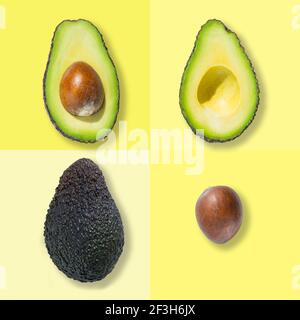 Draufsicht auf frische reife ganze Avocado-Frucht, halbiert und Knochen isoliert auf gelbem Hintergrund Stockfoto