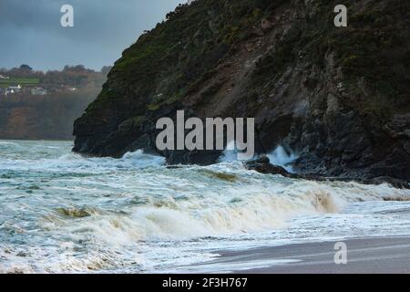 Atlantische Sturmwellen krachen auf und wuschen über Felsen und Sand am Carlyon Bay Beach in Cornwall am südwestküste von England Stockfoto