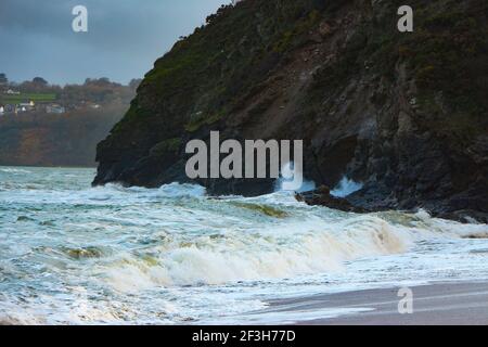 Atlantische Sturmwellen krachen auf und wuschen über Felsen und Sand am Carlyon Bay Beach in Cornwall am südwestküste von England Stockfoto