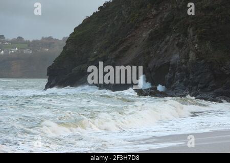 Atlantische Sturmwellen krachen auf und wuschen über Felsen und Sand am Carlyon Bay Beach in Cornwall am südwestküste von England Stockfoto