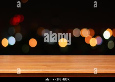 Holztischplatte auf buntem Bokeh Hintergrund in der Nacht Stockfoto