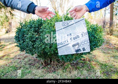 Lieferer, der Papiertüten überreicht Stockfoto