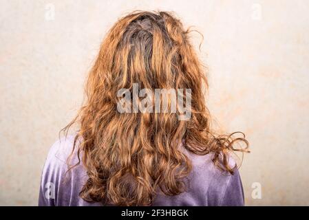 Die Frau sitzt im Raum mit dem Rücken zur Kamera. Haare müssen gefärbt werden. Haarpflege Stockfoto