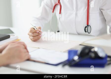 Arzt kümmert sich um den Patienten und nimmt Einträge in der medizinischen Aufzeichnen Stockfoto