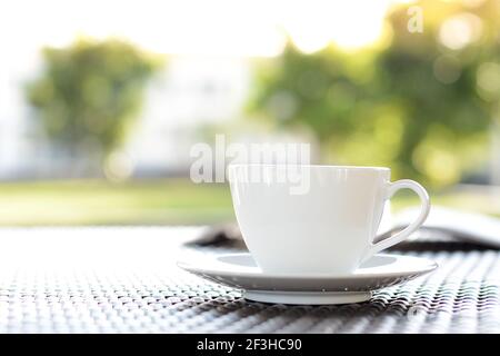 Kaffeetasse mit Buch auf verschwommenem grünen Natur Hintergrund - Chill-Out-Konzept Stockfoto