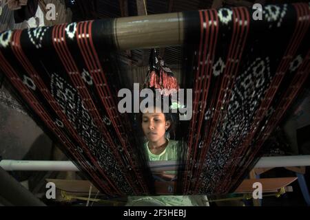 Wenty Fattu produziert traditionelle Webtextilien der Roten Insel im Dorf Ndao, Rote Insel, Rote Ndao Regentschaft, Provinz East Nusa Tenggara, Indonesien. Jeden Monat stellt ihre Familie drei Stoffe her, die zwischen 300.000 und 500.000 IDR kosten. Rote Insel, Ost-Nusa Tenggara, Indonesien. Stockfoto