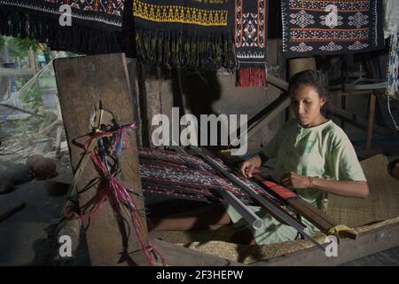 Wenty Fattu produziert traditionelle Webtextilien der Roten Insel im Dorf Ndao, Rote Insel, Rote Ndao Regentschaft, Provinz East Nusa Tenggara, Indonesien. Jeden Monat stellt ihre Familie drei Stoffe her, die zwischen 300.000 und 500.000 IDR kosten. Rote Insel, Ost-Nusa Tenggara, Indonesien. Stockfoto