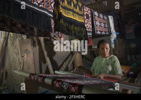 Wenty Fattu stellt traditionelle Gewebe von Rote Island her in Ndao Village, Rote Island, Rote Ndao Regentschaft, East Nusa Tenggara Provinz, Indonesien. Jeden Monat produziert die Familie drei Stoffe, die zwischen 300.000-500.000 IDR kosten. Rote Insel, Ost-Nusa Tenggara, Indonesien. Stockfoto