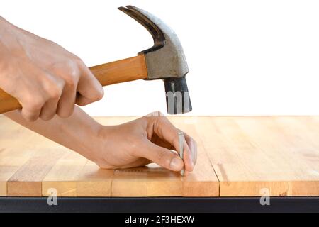 Hand hämmert einen Nagel auf Holz Tischplatte Stockfoto