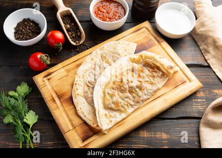 Aserbaidschanische Nationalgericht Gutab mit Fleisch und Gemüse zusammen mit Joghurt und Sumac auf Holztisch Stockfoto