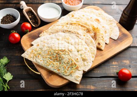 Aserbaidschanische Nationalgericht Gutab mit Fleisch und Gemüse zusammen mit Joghurt und Sumac auf Holztisch Stockfoto