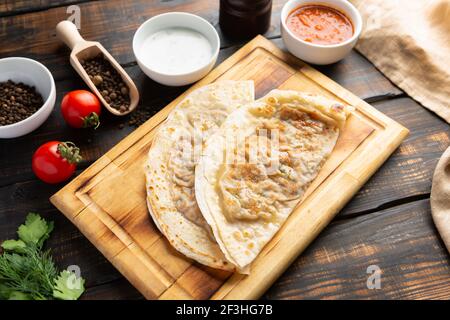 Aserbaidschanische Nationalgericht Gutab mit Fleisch und Gemüse zusammen mit Joghurt und Sumac auf Holztisch Stockfoto