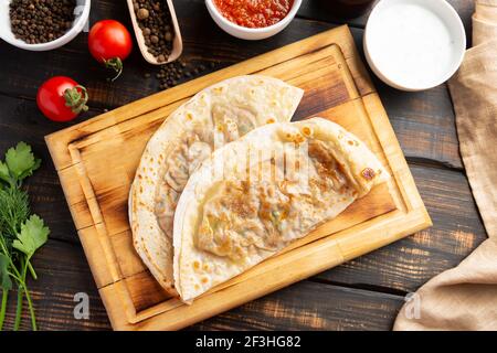 Aserbaidschanische Nationalgericht Gutab mit Fleisch und Gemüse zusammen mit Joghurt und Sumac auf Holztisch Stockfoto