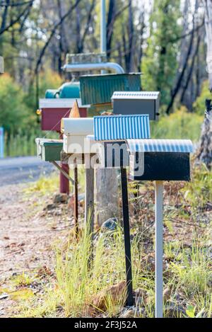 Eine Reihe von Briefkästen auf einer Landstraße im ländlichen NSW Australien. Briefkästen werden häufig zusammengebracht, um Zeit für Postarbeiter alias Posties zu sparen Stockfoto