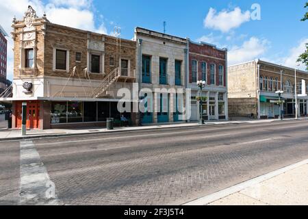 Renovierte Gebäude mit Mann saß auf Bank außerhalb Stadtzentrum San Antonio, Texas. Stockfoto