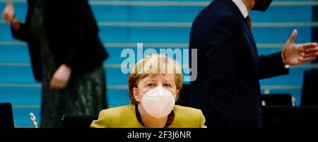 Berlin, Deutschland. März 2021, 17th. Bundeskanzlerin Angela Merkel trägt eine Schutzmaske, als sie auf den Beginn der wöchentlichen Kabinettssitzung wartet und hinter ihr gestikuliert. Quelle: Tobias Schwarz/AFP-Pool/dpa/Alamy Live News Stockfoto