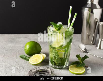 Erfrischender Mojito-Cocktail im Sommer mit Eiswürfeln, frischer Minze und Limette. Zutaten und Bar-Werkzeuge für die Herstellung Mojito Grink. Stockfoto