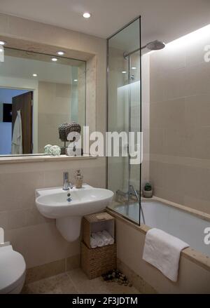 Wand montiert Waschbecken neben Badewanne in kleinen Bad in modernen Wohnungen, Hampton Wick. Stockfoto