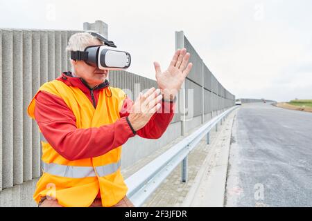 Architekt auf einer Straßenbaustelle nutzt VR-Brillen für Virtuelle Bauplanung Stockfoto