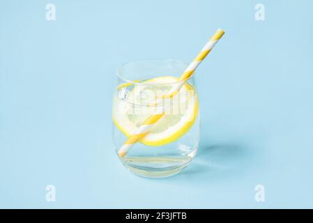 Glas Wasser mit Zitrone auf blauem Hintergrund. Stockfoto