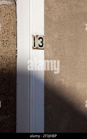 Haus Nummer 13 auf Kiesel gestrichelte Wand. Stockfoto