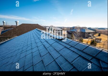 Eindeutige Frostlinie auf einem Schindeldach wie die Die Sonne trifft morgens auf den Grat Stockfoto