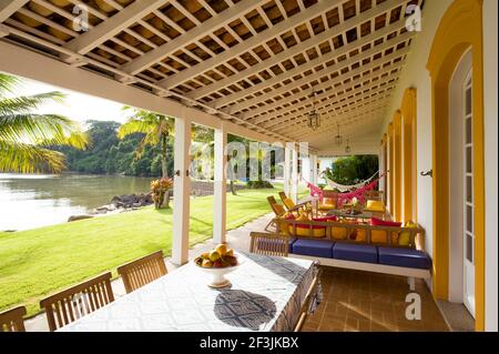 Privathaus in Parati Brasilien. Hinteren Terrasse, mit Blick aufs Meer mit Tisch und Stühlen. Dekoriert mit Kissen. Stockfoto