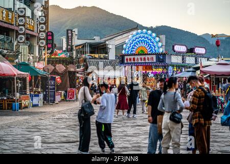 Kunming China , 3 Oktober 2020 : Bunte Geschäfte und Restaurants am Eingang von Xishan szenische Gegend bei Sonnenuntergang mit dramatischem Licht in Kunming Yunnan Stockfoto