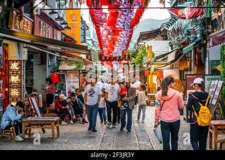 Kunming China , 3 Oktober 2020 : Menschen in bunten Fußgängerzone Restaurant und Geschäfte Gasse am Eingang von Xishan malerischen Bereich bei Sonnenuntergang in Kunming Y Stockfoto