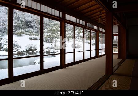 Atemberaubender japanischer Wintergarten mit Blick vom Inneren des traditionellen Zimmers mit Panoramafenstern. Stockfoto