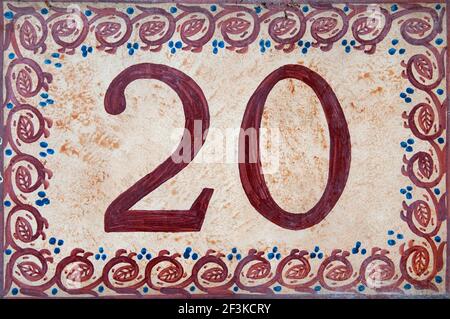 Eine Nahaufnahme der Zahl zwanzig Hand bemalt auf Zu EINER dekorativen Keramikfliese Stockfoto