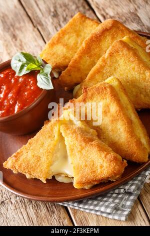 Mozzarella in Carrozza Italienische Sandwiches mit Sauce in der Nähe auf dem Teller auf dem Tisch. Vertikal Stockfoto