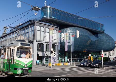 Eine traditionelle Straßenbahn fährt am kunsthaus Graz (2003), Steiermark, Österreich vorbei Stockfoto