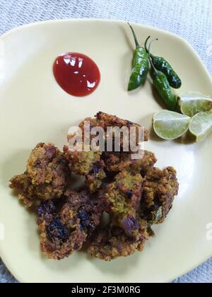 Indische dal pakora Rezept mit Tomatensauce grün kühl und Zitronenstücke auf einem Teller Stockfoto