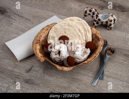 Dekorative kunstvolle Keramikplatte mit Schokoladentrüffel und Baiser-Kekse, Nahaufnahme. Stockfoto
