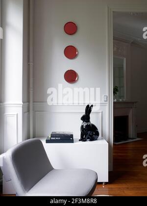 Zierkaninchen mit drei roten Zierteller in französischer Wohnung. Stockfoto