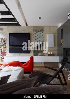 Offener Wohnbereich mit an der Wand montiertem Fernseher in französischem Wohnhaus. Stockfoto