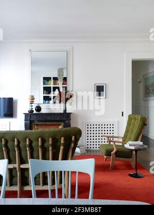 Wohnbereich mit Kamin, Spiegel, Sofa und Sesseln in französischem Wohnhaus. Stockfoto