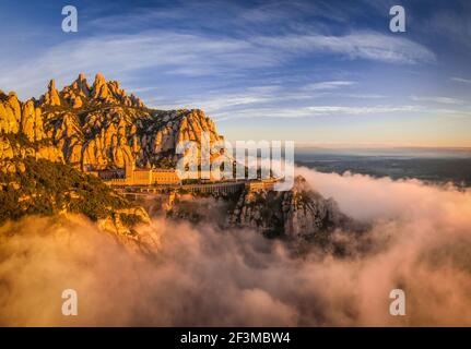 Montserrat und Kloster Montserrat bei Sonnenaufgang mit einem Meer aus Wolken vom Aussichtspunkt Creu de Sant Miquel aus gesehen (Provinz Barcelona, Katalonien, Spanien) Stockfoto
