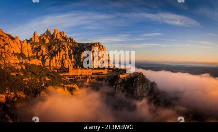 Montserrat und Kloster Montserrat bei Sonnenaufgang mit einem Meer aus Wolken vom Aussichtspunkt Creu de Sant Miquel aus gesehen (Provinz Barcelona, Katalonien, Spanien) Stockfoto