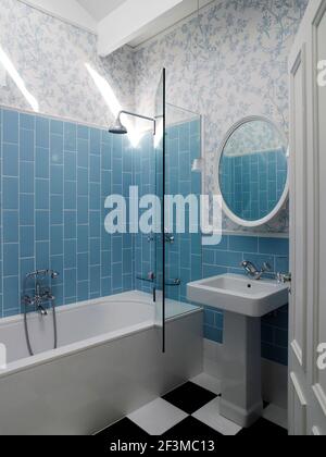 Blau gefliestes Badezimmer mit Glasduschwand in einem Wohnhaus in Australien Stockfoto