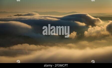 Wolkenmeer bei Sonnenaufgang vom Aussichtspunkt Creu de Sant Miquel in Montserrat (Provinz Barcelona, Katalonien, Spanien) aus gesehen Stockfoto