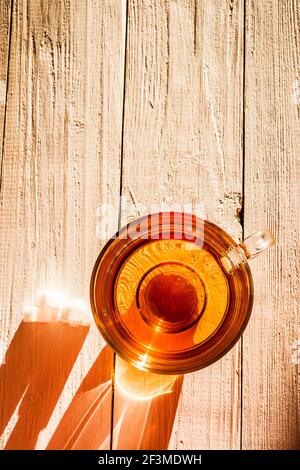 Bild von Glas Tasse mit Tee und Zucker auf Holz- Oberfläche. Stockfoto